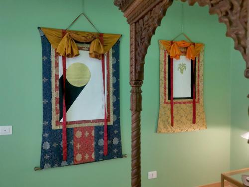 two windows on a green wall with curtains at Speciale Tarshito Guesthouse Bari in Bari