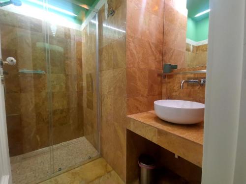 a bathroom with a sink and a glass shower at Speciale Tarshito Guesthouse Bari in Bari