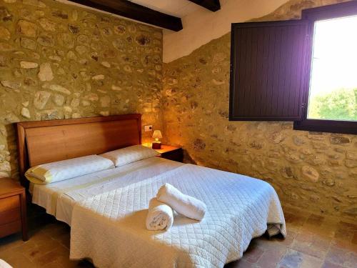 a bedroom with a bed with towels on it at Masía para grupos con piscina privada-28 pax in Girona