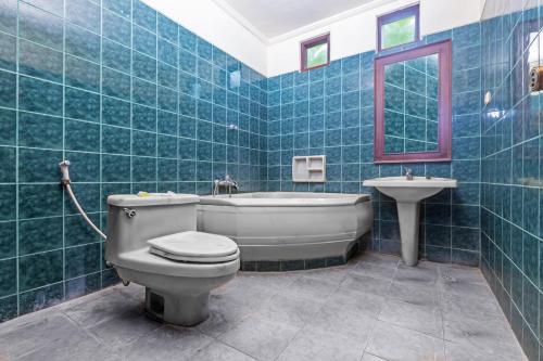 a bathroom with a tub and a toilet and a sink at Dewi Sinta Hotel and Restaurant in Tanah Lot