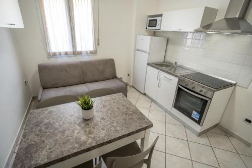 a small kitchen with a table and a couch at Rimini Bay Suites&Residence in Rimini