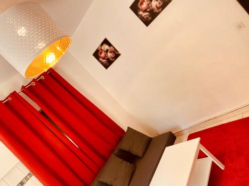 - un salon avec des rideaux rouges et un lustre dans l'établissement Belle villa à 5 mn du centre avec grd jaccuzy, à Montpellier