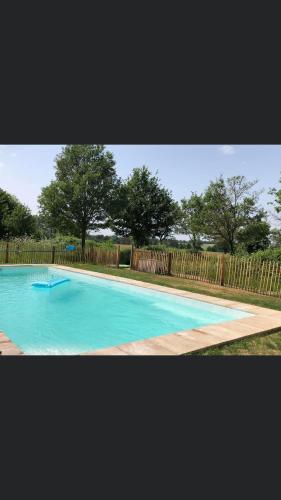 une grande piscine bleue avec une clôture en bois dans l'établissement Maison d'amis, à Chaumont