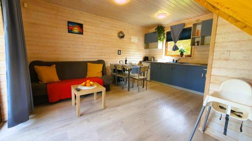 mały salon z kanapą i kuchnią w obiekcie Kolorowe Domki w Gąskach