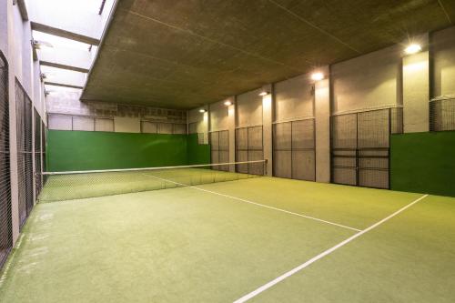 an empty tennis court in a building with lights at Parador de La Granja in La Granja de San Ildefonso