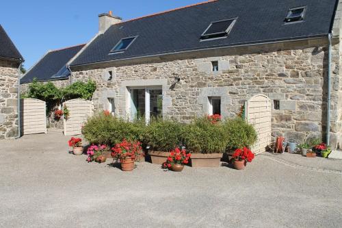 a stone building with potted plants in front of it at La Maison de Lésa in Poullan-sur-Mer