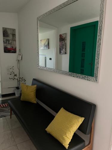 a living room with a black couch and a mirror at B&B Le Terrazze in Crotone