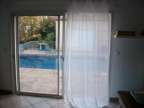 a sliding glass door with a view of a pool at Maison d'Hotes Le Boulou in Saint-Cyr-sur-Mer