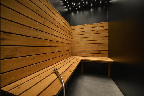 a wooden sauna with a bench in a room at Maxmilian Lifestyle Resort in Loučeň