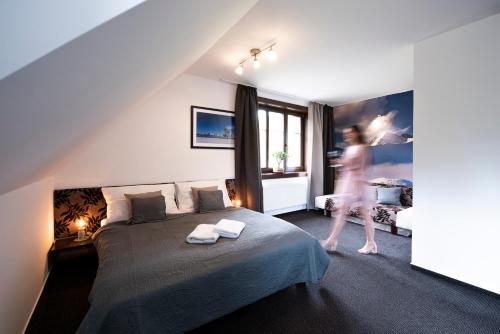 a woman walking in a bedroom with a bed at Penzion Sileo in Pribylina