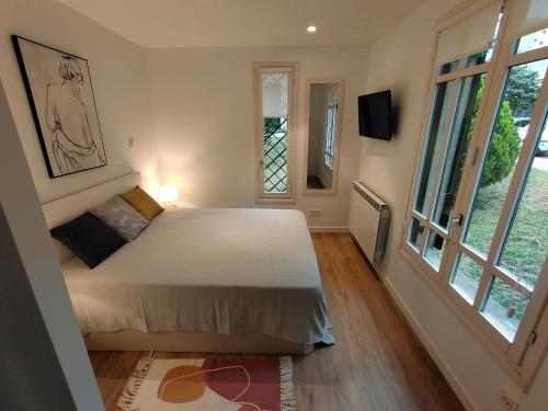 um quarto com uma cama e uma grande janela em La casa de la brujita with AC em San Sebastián