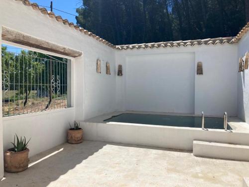 una camera bianca con una grande finestra e una piscina di LosGuachos_ casa rural a Villalgordo del Jucar
