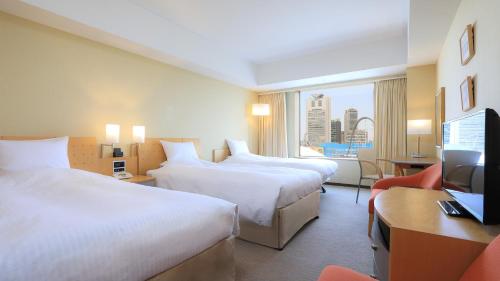 a hotel room with two beds and a television at Tokyo Dome Hotel in Tokyo