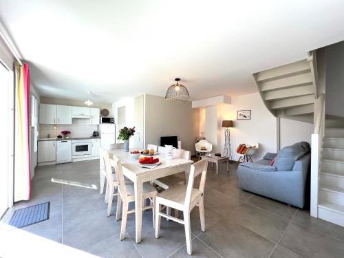 cocina y sala de estar con mesa y sillas en Le Clos des Vieux Moulins, en La Flotte