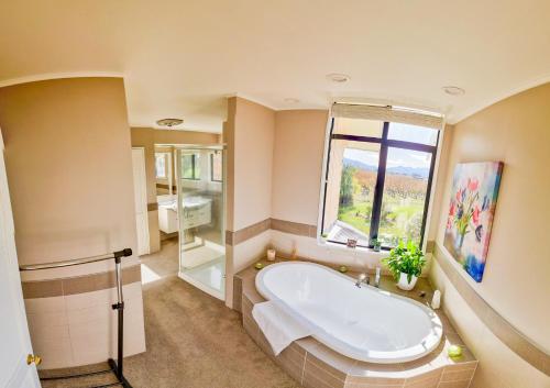 a large bathroom with a tub and a window at Fairhall Lodge in Blenheim