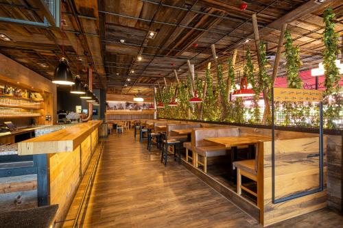um restaurante com mesas e bancos de madeira e vasos de plantas em JOESEPP´S HOTEL am Schweizerberg em Memmingen