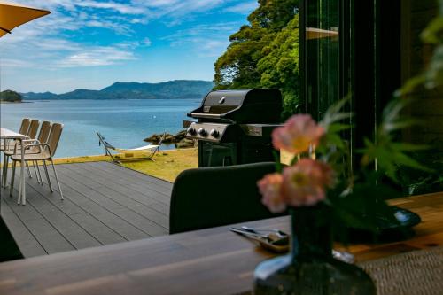 a patio with a grill and a table with a view of the water at 佐世保VILLA青鹿Ur1 in Sasebo