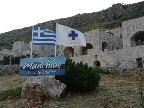 a sign in front of a building with two flags at Mani Blue Studios in Oítilon