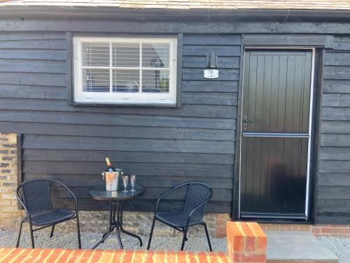 eine Terrasse mit einem Tisch und Stühlen vor einem Haus in der Unterkunft The Lydden Bell in Dover