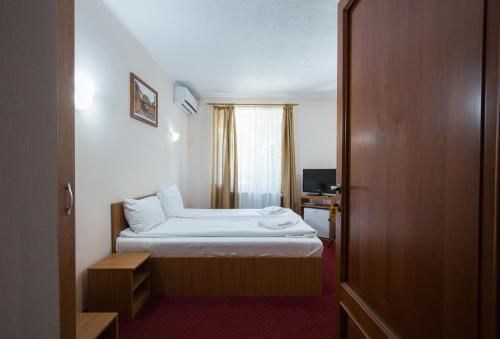 a hotel room with a bed and a window at Dumbrava Sibiului in Sibiu