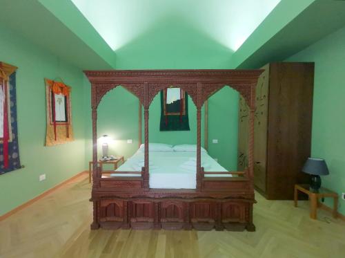 a canopy bed in a room with green walls at Speciale Tarshito Guesthouse Bari in Bari