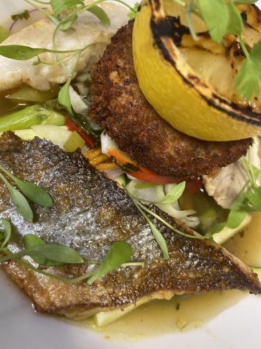 a plate of food with fish and a lemon on it at The Lydden Bell in Dover