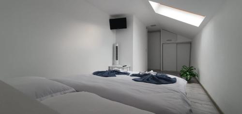 a white bedroom with a large bed with blue towels on it at Apartament La Sika in Orşova