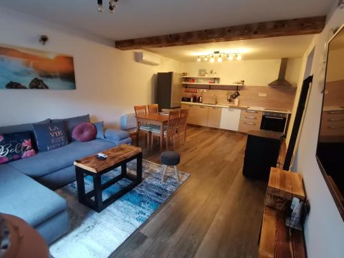 ein Wohnzimmer und eine Küche mit einem Sofa und einem Tisch in der Unterkunft Vila Bella in Plitvička Jezera