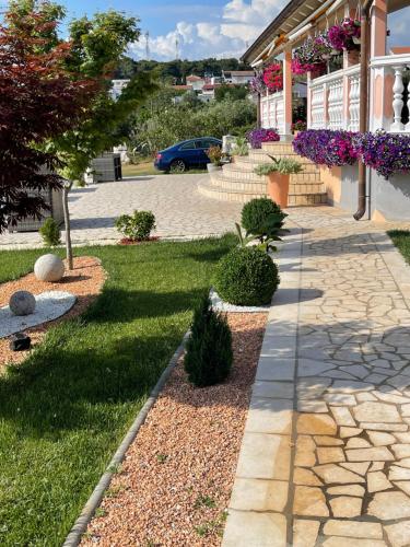 a garden with a stone walkway next to a house at Villa Natalija in Medulin