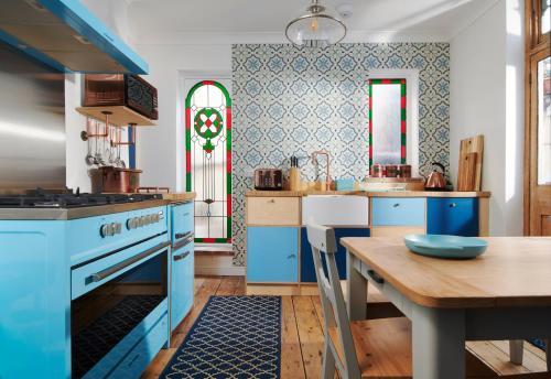 uma cozinha com armários azuis e uma mesa de madeira em Refurbished Seaside Retreat in the Heart of Cromer em Cromer