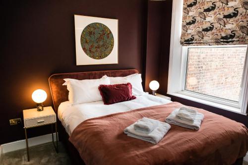 a bedroom with a bed with towels on it at Maison Mouettes by Luxury Travel Emporium - Luxury Suites with Abbey Views in Whitby