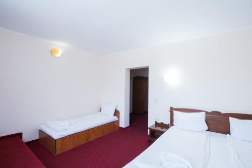 a hotel room with two beds and a table at Dumbrava Sibiului in Sibiu