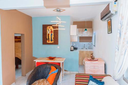 a kitchen with blue walls and a table and chairs at MOOKSQUARE NS SPOT in Douala