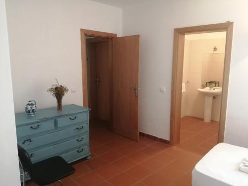 Schlafzimmer mit blauer Kommode und Bad in der Unterkunft Casa da Osga in Tavira