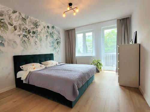 a bedroom with a bed and a large window at Apartament Arkadia Augustow in Augustów