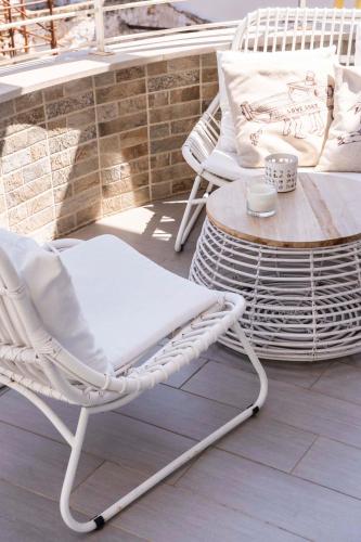 a white wicker chair sitting on a patio at San Vito Luxury Accomodation in Polignano a Mare