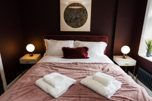 a bedroom with a bed with two towels on it at Maison Mouettes by Maison Parfaite - Luxury Suites with Abbey Views in Whitby