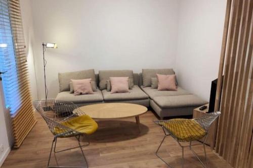 uma sala de estar com um sofá, uma mesa e cadeiras em Aux MARCHES DU PALAIS - AC CLIM - SPACIEUX - TERRASSE - WIFI em Avignon