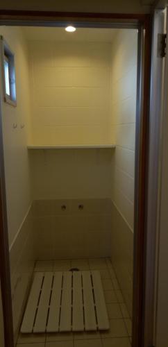 a room with a shower with a bench in it at ペンション村山里 in Yamazatu