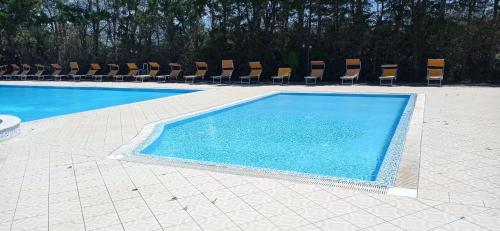 a swimming pool with chairs and blue water at Tenuta Don Monaco - Agriturismo in Santa Cesarea Terme