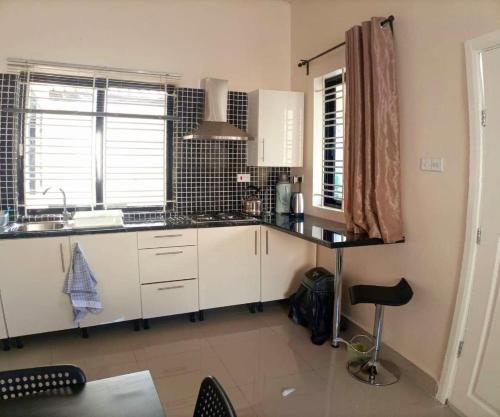 a kitchen with white cabinets and a sink at Portersville Private Lodge in Freetown