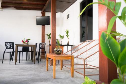 a patio with a table and chairs and a tv at Palm Gate Maldives in Thulusdhoo