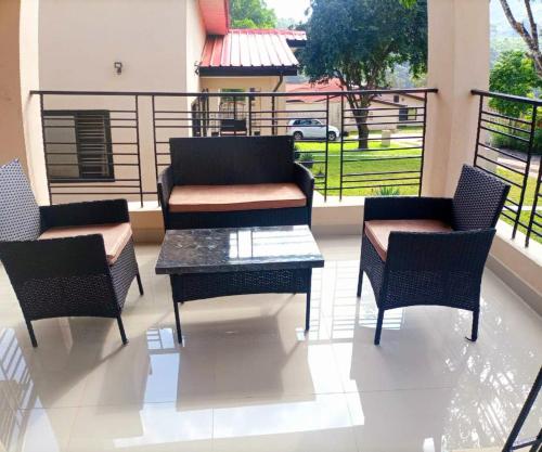 a patio with chairs and a table and a balcony at Portersville Private Lodge in Freetown