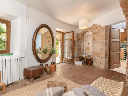 uma sala de estar com um espelho grande e uma parede de pedra em Preciosa casa rural en el centro de Peratallada em Peratallada