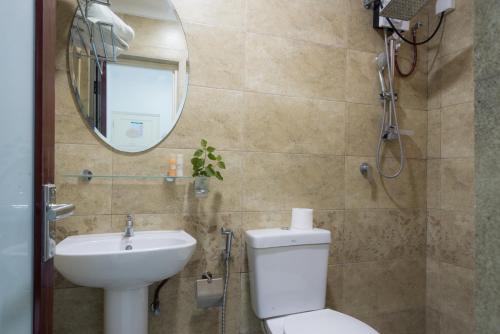 a bathroom with a toilet and a sink and a mirror at Palm Gate Maldives in Thulusdhoo