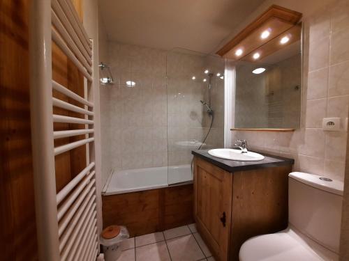 a bathroom with a sink and a tub and a toilet at Appartement Les Menuires, 4 pièces, 8 personnes - FR-1-452-81 in Les Menuires