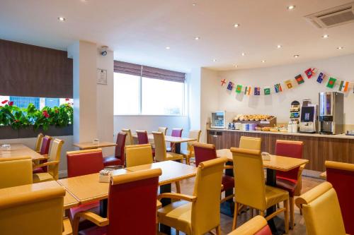 a dining room with tables and yellow chairs at Comfort Inn Edgware Road W2 in London