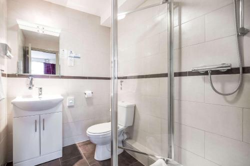 a bathroom with a toilet and a glass shower at Comfort Inn Edgware Road W2 in London