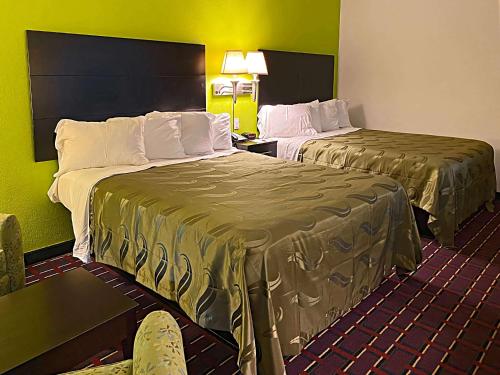 duas camas num quarto de hotel com paredes verdes em Quality Inn Henderson I-85 em Henderson