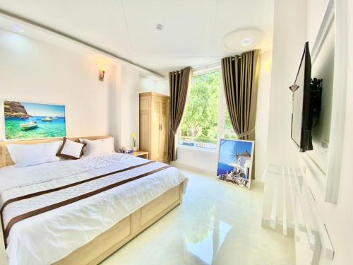 sypialnia z łóżkiem i dużym oknem w obiekcie CAROLINE BEACH VUNG TAU w mieście Vung Tau